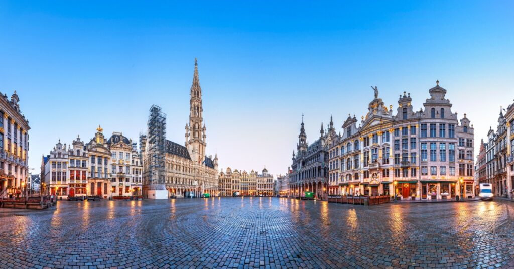 Panoramic view of Brussels’ Grand Place with ornate historic buildings surrounding the square at dawn.