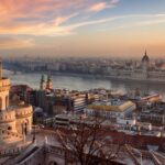 Sunset view of Budapest featuring Fisherman’s Bastion towers and the Hungarian Parliament across the Danube River.
