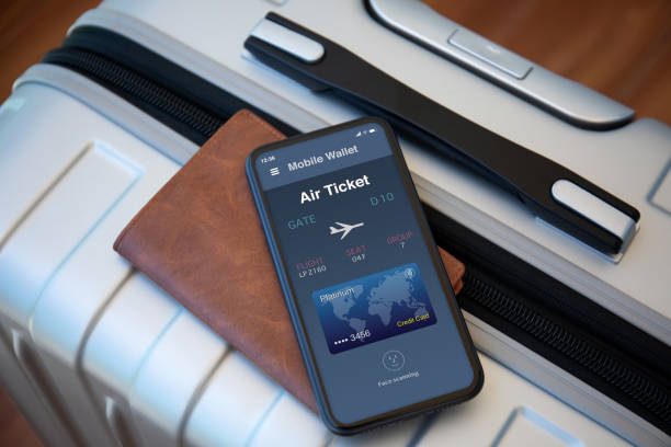 Smartphone displaying a digital air ticket resting on a suitcase next to a leather wallet.