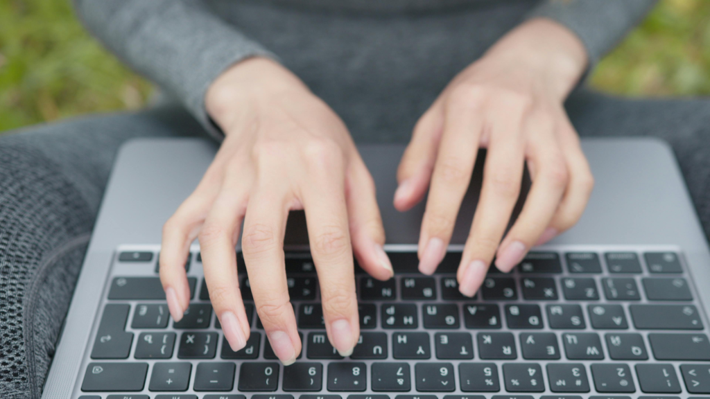 Close-up of hands typing on a laptop keyboard, focused on work or writing tasks.