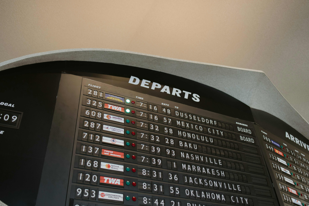 Photograph of a vintage airport departures board listing international flights.