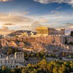 Parthenon temple on the Acropolis in Athens at sunset overlooking the city and surrounding hills.