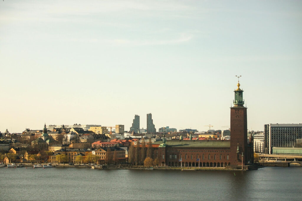 Stockholm City Hall and waterfront skyline viewed across the water under a clear sky.