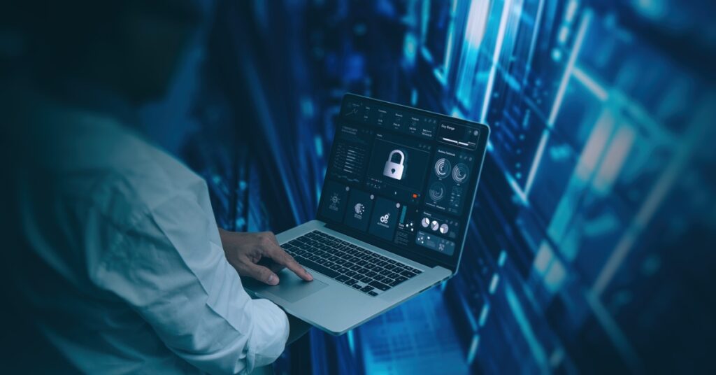 Person holding a laptop with a security lock interface in a data center environment.