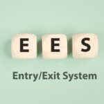 Wooden blocks spelling EES above the words “Entry/Exit System” on a green background.