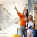 Family with luggage and passports at an airport terminal, looking ahead as they prepare for a trip