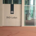 IND-Loket sign displayed at the entrance of a modern government office building