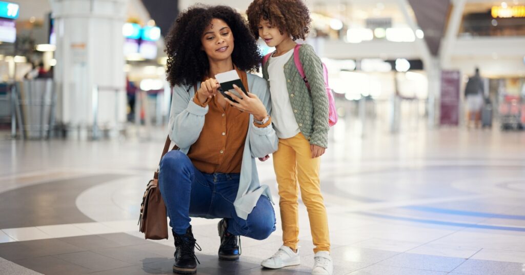 Mother and child check a passport together in an airport terminal before their journey