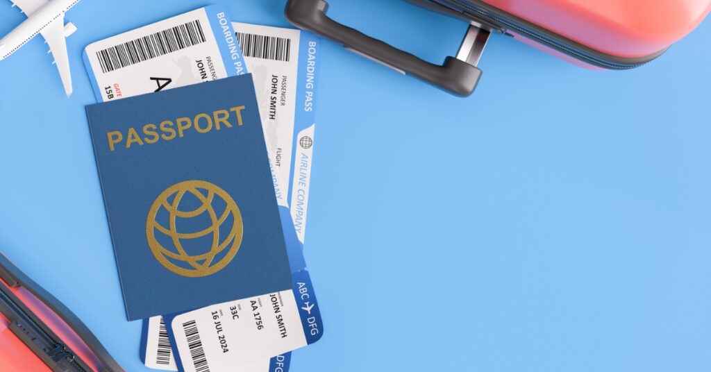 Passport with boarding passes beside a suitcase and model aeroplane on a blue background, representing air travel