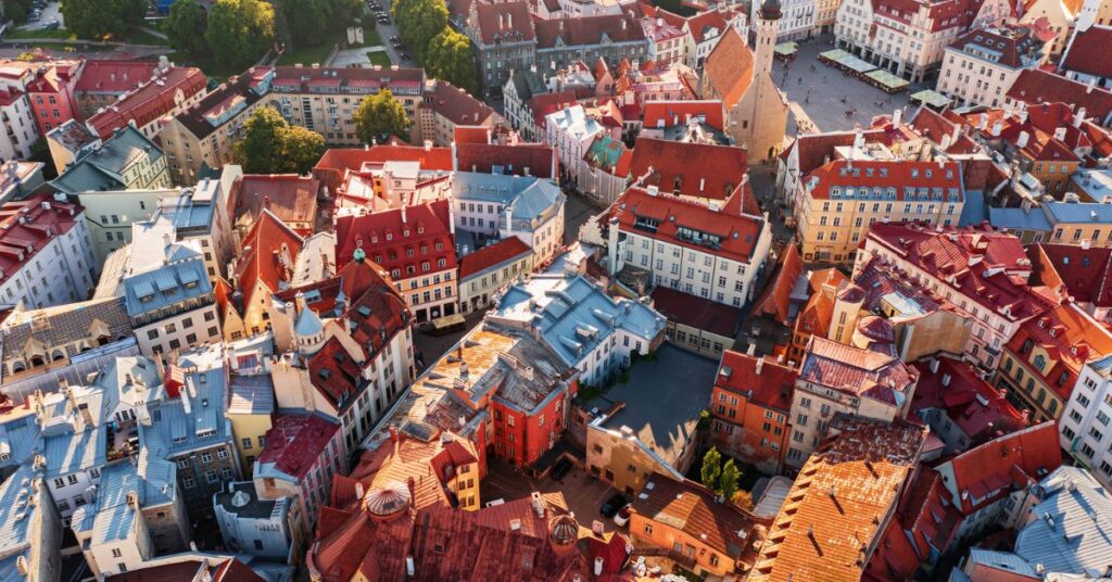Aerial view of Tallinn Old Town, showing red-tiled rooftops, historic buildings and a church tower