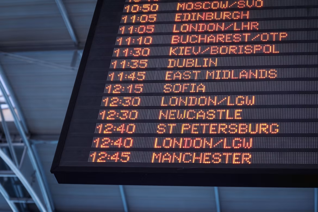 Airport departures board listing flights to cities including London, Dublin, Sofia and Manchester