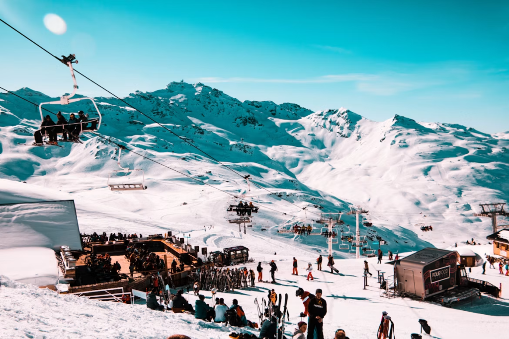 Ski resort with chairlifts carrying visitors over snowy mountain slopes under a clear blue sky