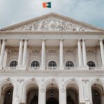 Portugal’s Parliament building in Lisbon, with neoclassical columns, broad steps and the Portuguese flag overhead