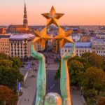 Freedom Monument holding three stars above Riga’s city centre at sunset