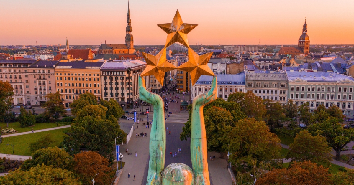 Freedom Monument holding three stars above Riga’s city centre at sunset