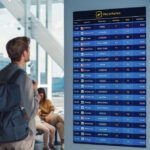 Traveller with a backpack checks a departures board in a modern airport terminal